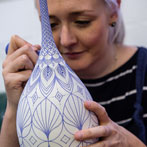 Rhian Malin decorating a mandala bottle in her workshop 2019
